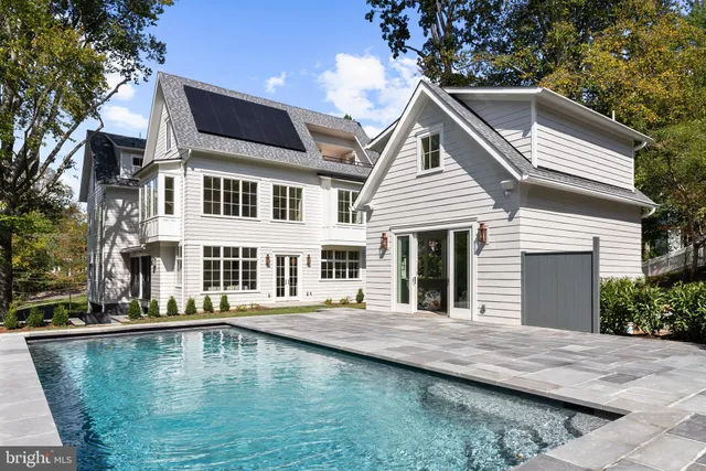 a view of a house with pool and chairs