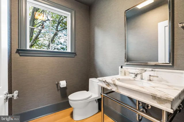 a bathroom with a sink a toilet and a mirror