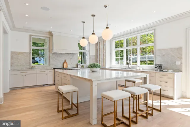 a kitchen with a dining table chairs sink and cabinets