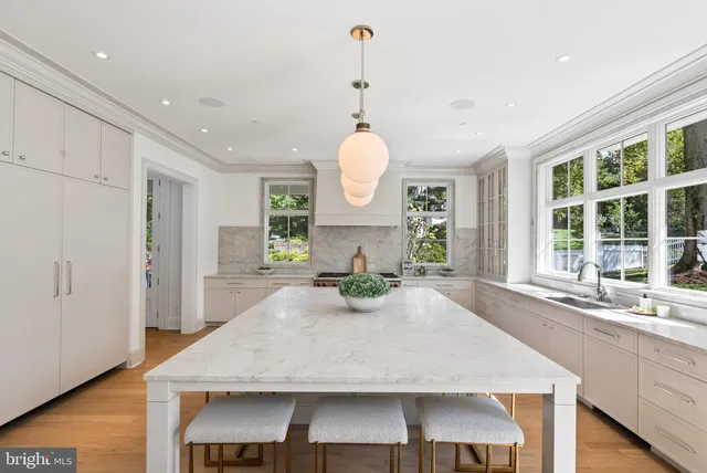 a kitchen with kitchen island a dining table and chairs
