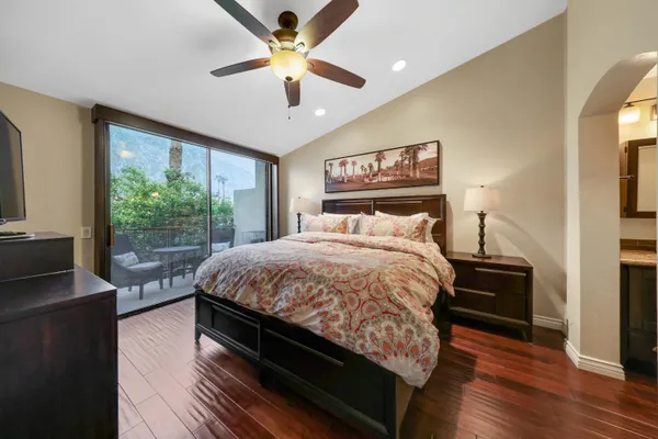a bedroom with a large bed chandelier and a large window