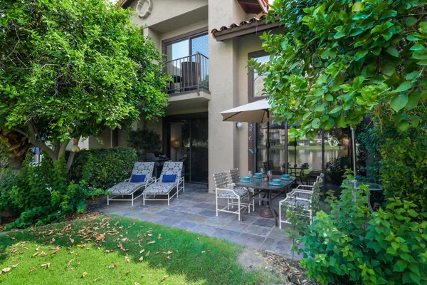 a view of a chair and table in backyard of the house