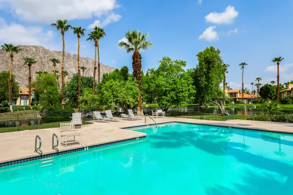 a white house with a big yard and palm trees