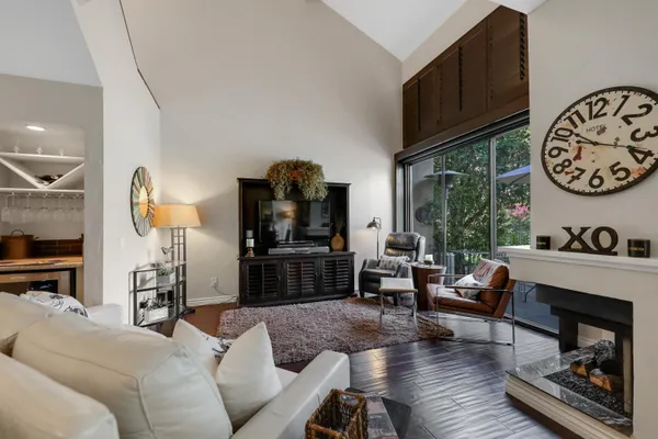 a living room with furniture a fireplace and a large window