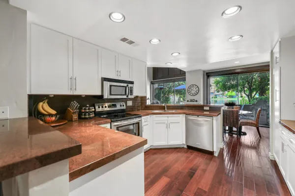 a kitchen with stainless steel appliances granite countertop sink stove top oven and cabinets