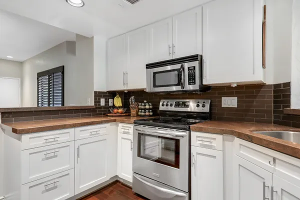 a kitchen with granite countertop white cabinets and appliances