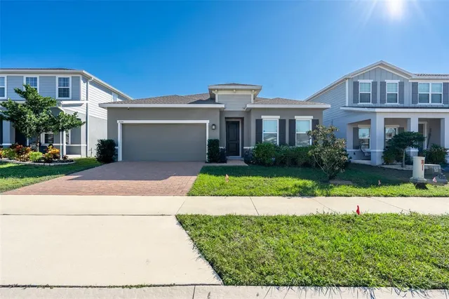 a front view of a house with a yard and potted plants
