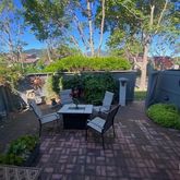 a view of a patio with table and chairs potted plants and large tree