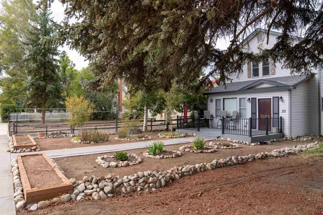 a view of a house with backyard and trees