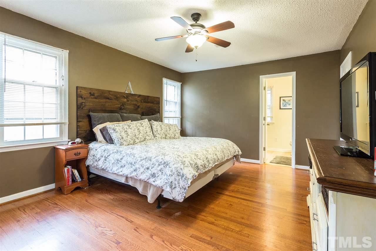 7613 Leesville Road Raleigh, NC 27613 - Photo 21 of 30 a bedroom with a bed and a flat tv screen on dresser