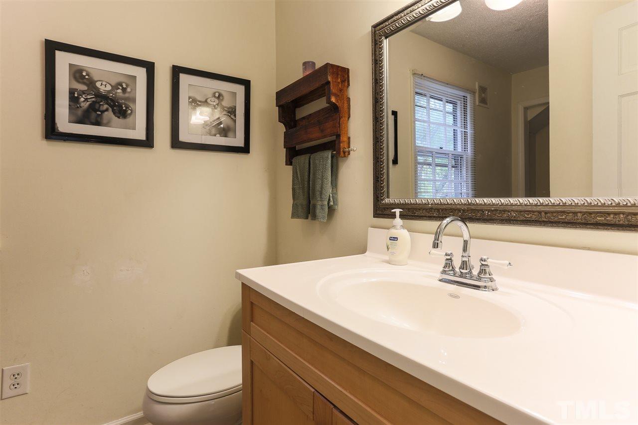 7613 Leesville Road Raleigh, NC 27613 - Photo 22 of 30 a bathroom with a sink a toilet and mirror