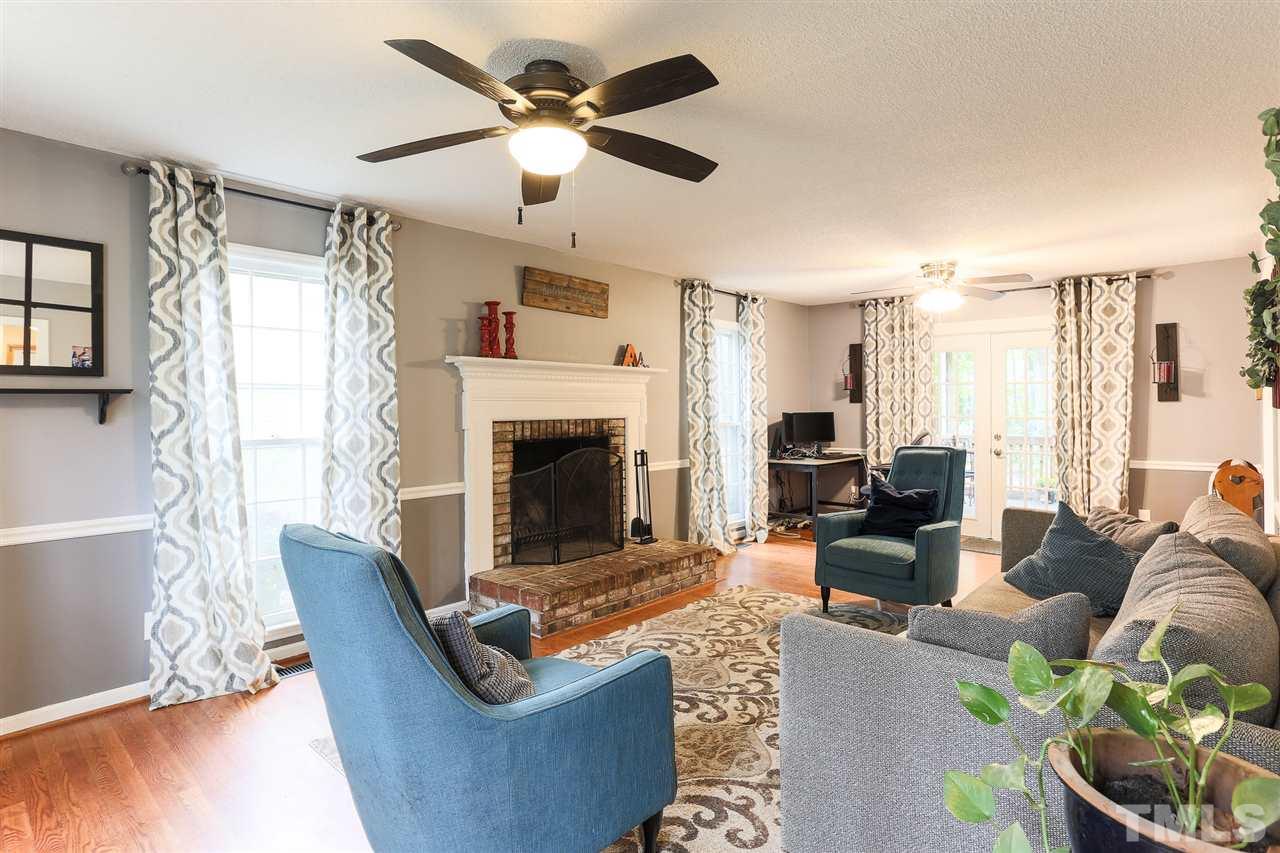 7613 Leesville Road Raleigh, NC 27613 - Photo 5 of 30 a living room with furniture a fireplace and a large window