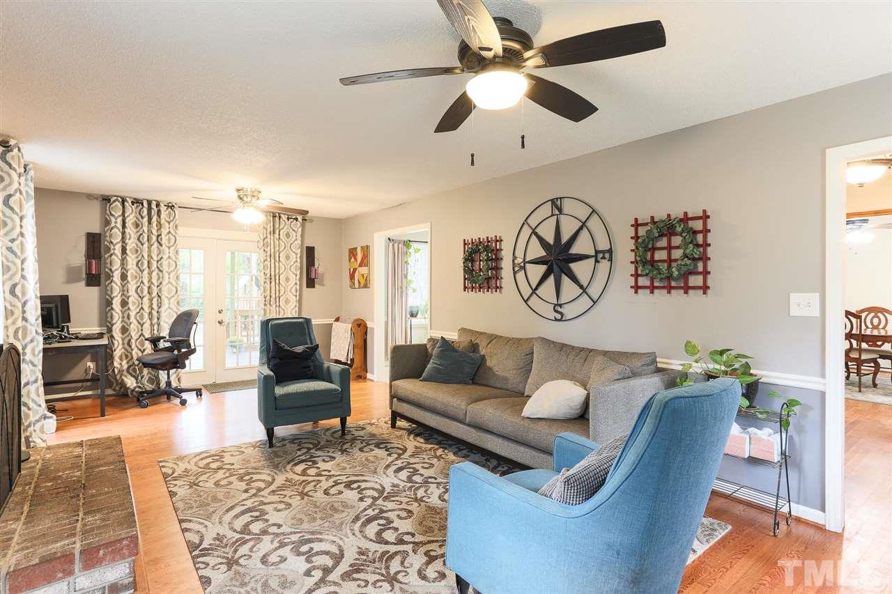 7613 Leesville Road Raleigh, NC 27613 - Photo 6 of 30 a living room with furniture a rug and a chandelier