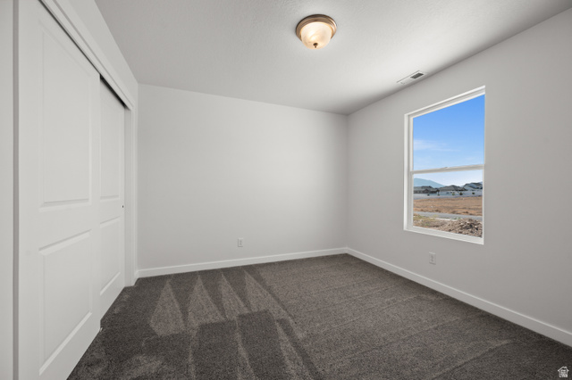 1554 Pheasant Road Eagle Mountain, UT 84005 - Photo 26 of 29 Unfurnished bedroom with a closet and dark colored carpet