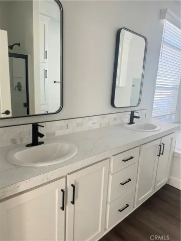 a bathroom with a double vanity sink and a mirror