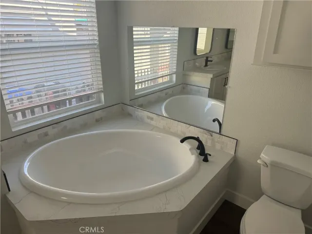 a white bath tub sitting next to a toilet