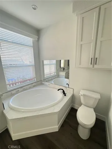 a spacious bathroom with toilet and a bathtub