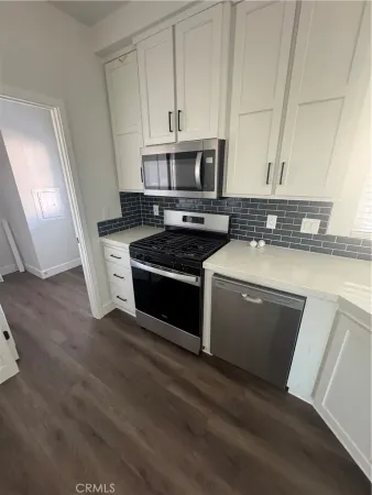 a kitchen with stainless steel appliances granite countertop a stove a sink and a microwave