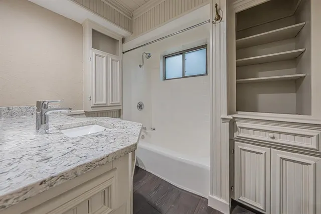 a bathroom with a granite countertop sink and mirror