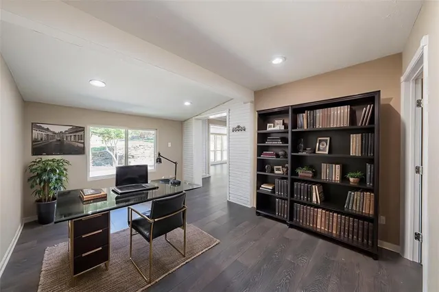 a living room with furniture a bookshelf and a window