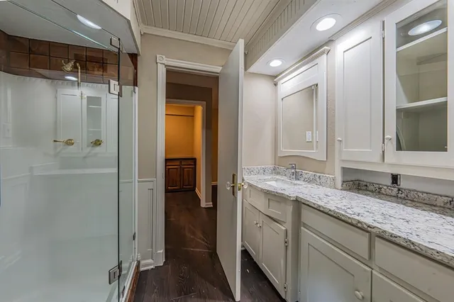 a bathroom with a granite countertop sink mirror and shower