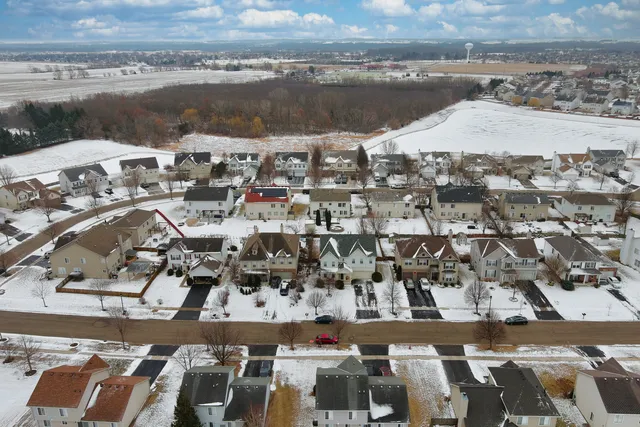 a kitchen with stainless steel appliances a dining table chairs and a refrigerator