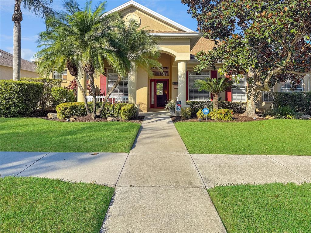 a front view of a house with a yard and potted plants