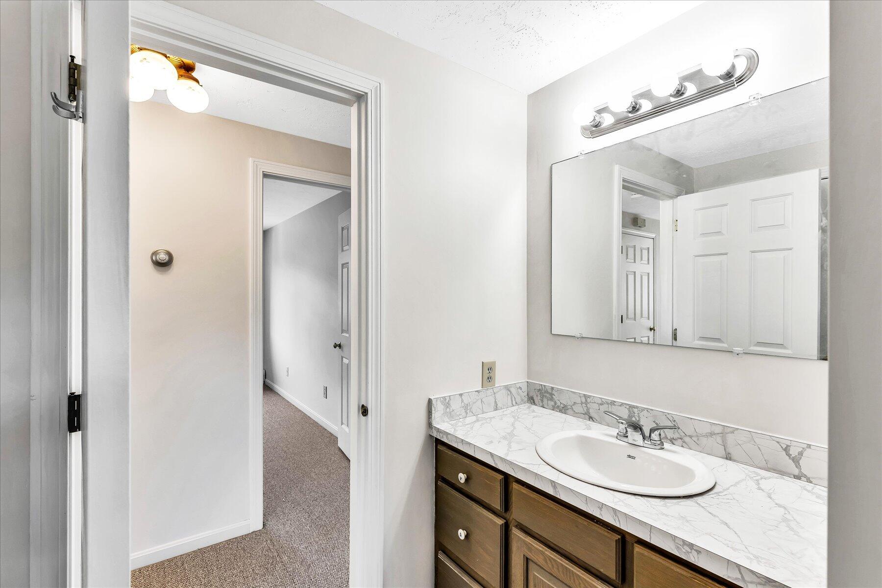 19 Mashnee Road Bourne, MA 02532 - Photo 34 of 46 a bathroom with a granite countertop sink and a mirror