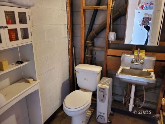 74 Adams Road Wofford Heights, CA 93285 - Photo 14 of 15 a white toilet sitting next to a bathroom sink and a mirror