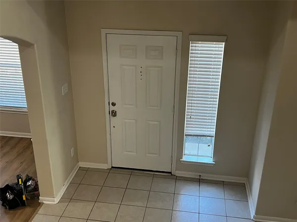 a view of an empty room with closet and a window