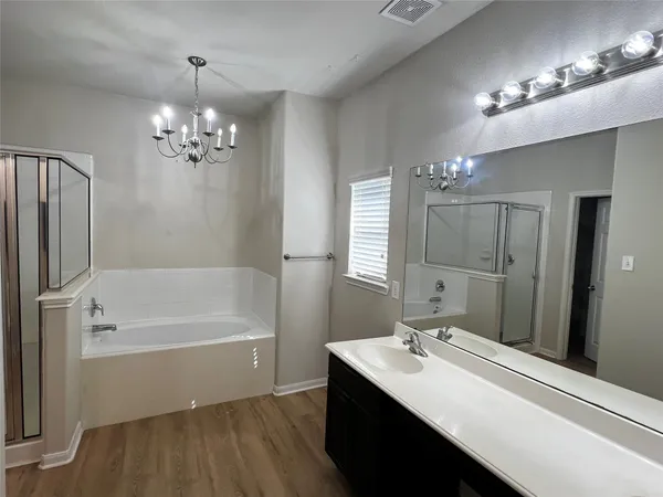 a bathroom with a tub sink and mirror