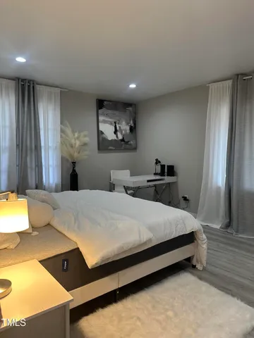 a bedroom with a bed and a lamp on dresser