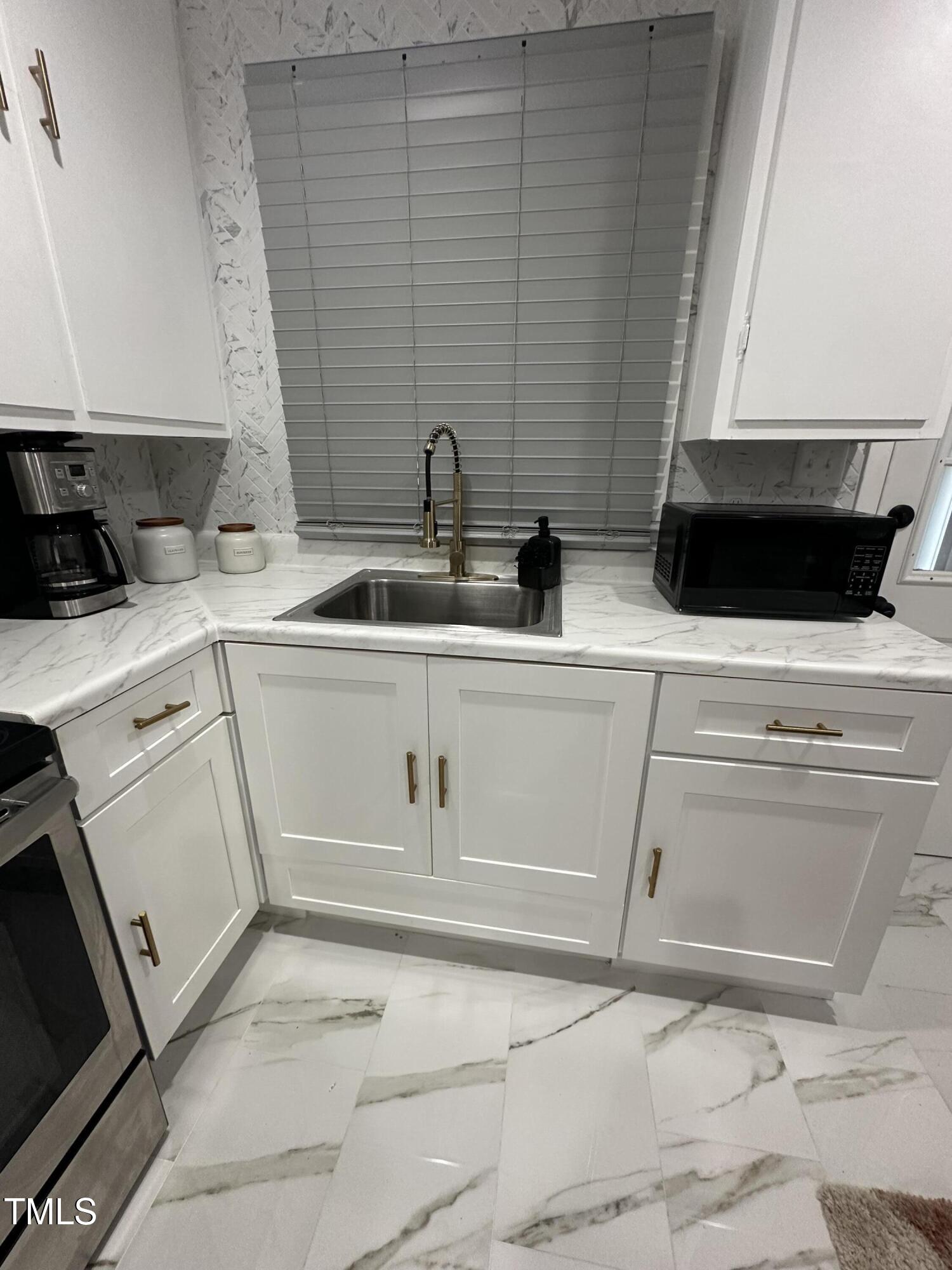 1216 Elizabeth Road West Wilson, NC 27893 - Photo 6 of 34 a kitchen with white cabinets and white appliances