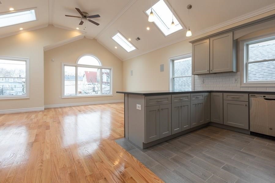 a large kitchen with cabinets wooden floor and a window