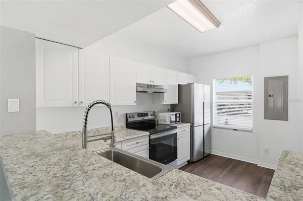 a kitchen with stainless steel appliances granite countertop a stove a sink and a refrigerator