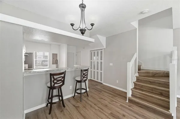 a view of a room with wooden floor and chairs