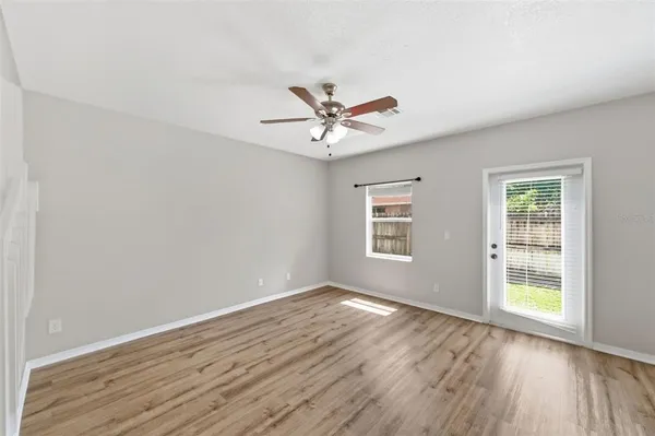 an empty room with wooden floor and windows