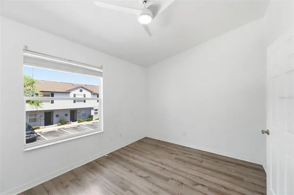 an empty room with wooden floor and windows