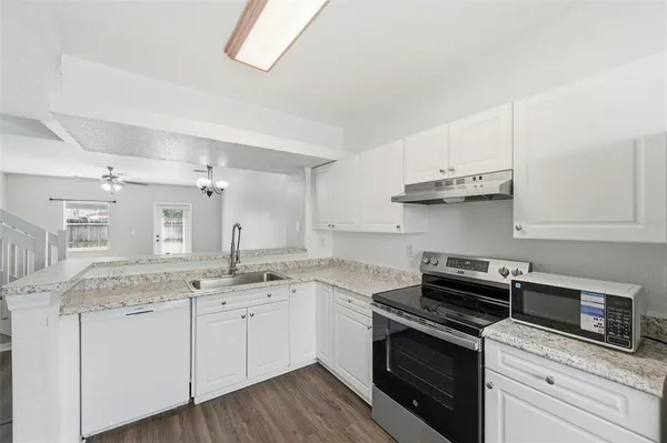 a kitchen with stainless steel appliances granite countertop a sink and stove top oven