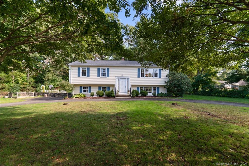 a view of a house with a big yard and large trees