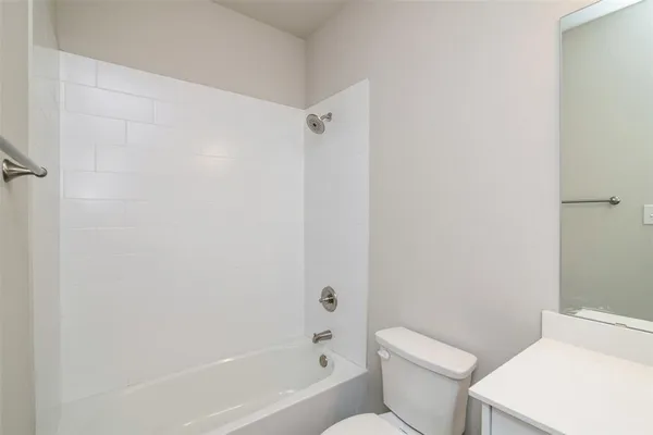 a white toilet sitting next to a bath tub