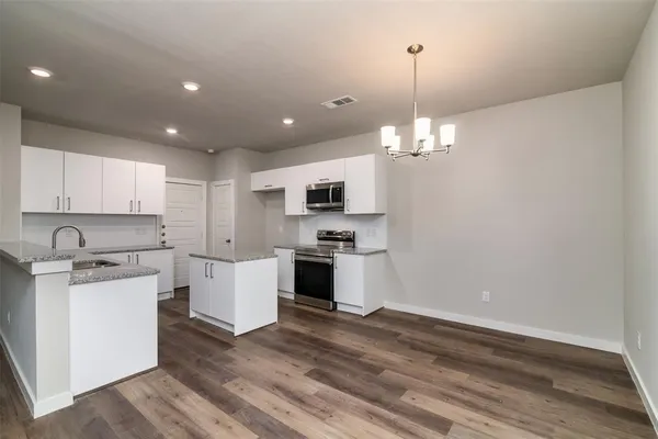a kitchen with a white stove cabinets and wooden floor