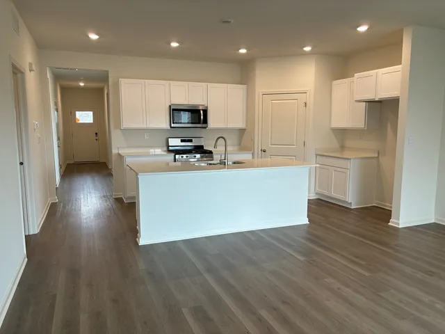 a kitchen with a sink cabinets and wooden floor
