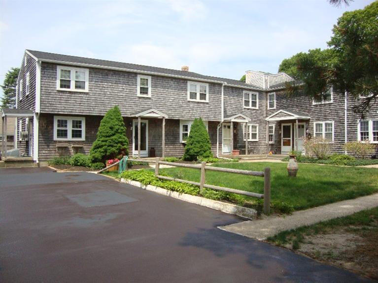 a front view of a house with a yard and potted plants