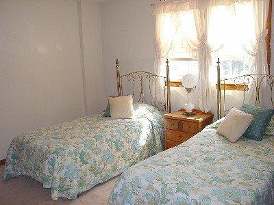 67 Inman Road, Unit F Dennis Port, MA 02639 - Photo 10 of 11 a bedroom with two beds and a large window