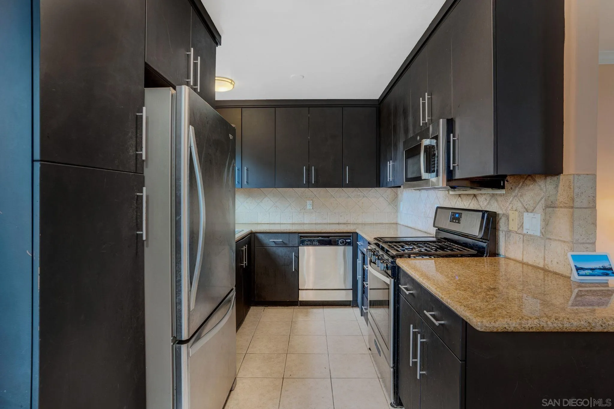 575 7th Street, Unit 104 Imperial Beach, CA 91932 - Photo 5 of 23 a kitchen with stainless steel appliances granite countertop a refrigerator a stove a sink and a microwave