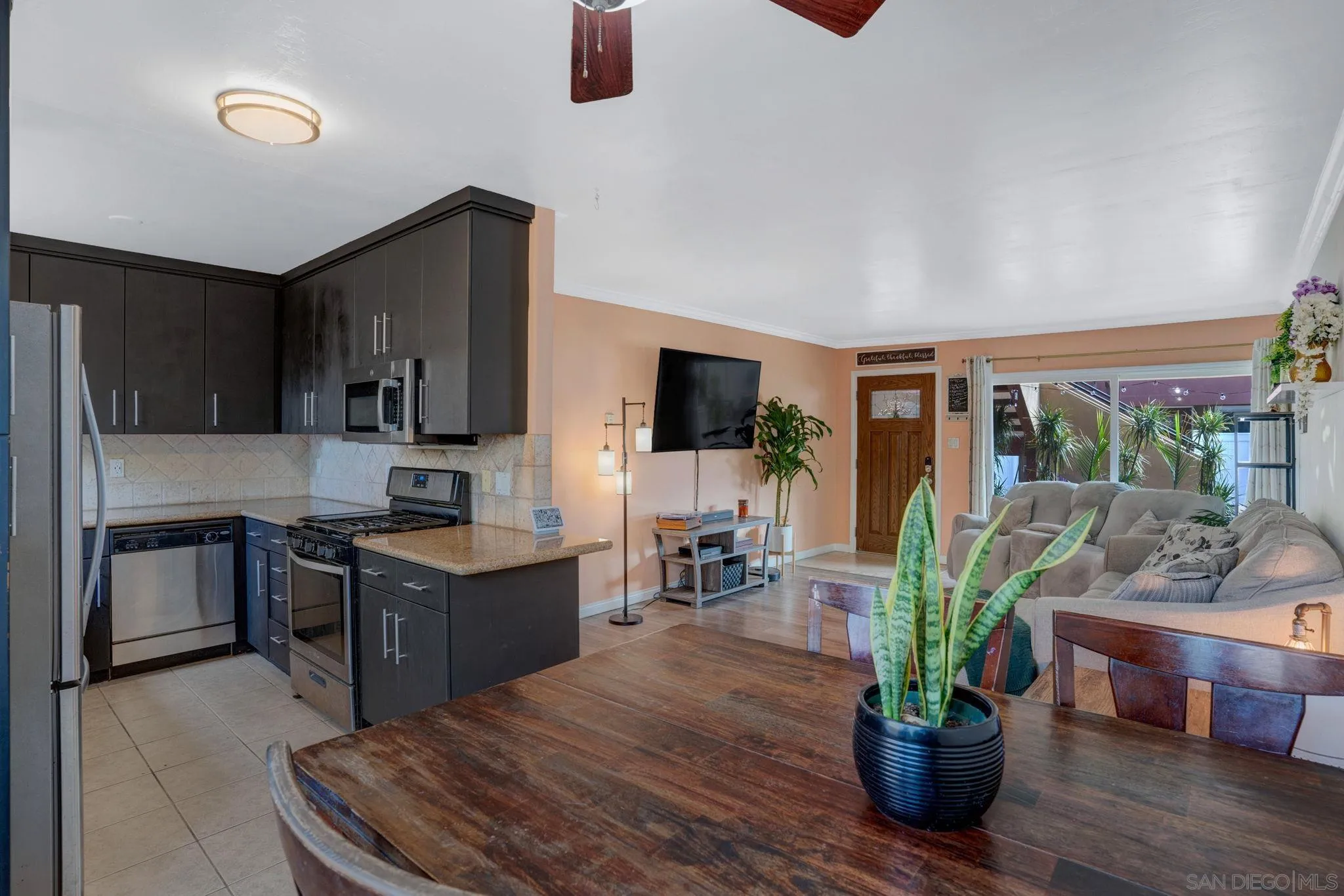 575 7th Street, Unit 104 Imperial Beach, CA 91932 - Photo 10 of 23 a kitchen with stainless steel appliances kitchen island granite countertop a refrigerator a stove top oven a sink with wooden floor