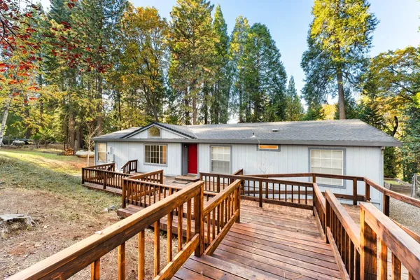 a view of a wooden deck and trees with wooden fence