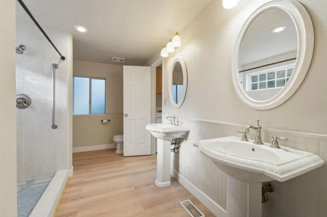 a bathroom with a double vanity sink mirror and shower
