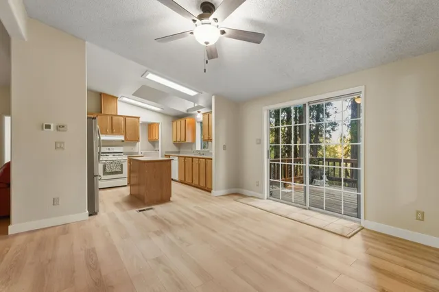 a view of a kitchen with wooden floor and a ceiling fan
